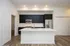 Modern kitchen with sleek black cabinets, white countertops, and stainless steel appliances, perfect for culinary enthusiasts.