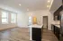 Inviting open-concept kitchen and living space featuring sleek dark cabinetry, modern lighting, and expansive windows for natural light.