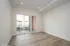 Bright, spacious room with wood flooring and large sliding glass door leading to a charming private balcony.