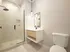 Modern bathroom with sleek glass shower, elegant vanity, and minimalist design, bathed in natural light.