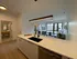 Bright and modern open-concept apartment kitchen and living area featuring stylish countertops, ample natural light, and elegant decor.