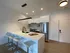 Modern kitchen with sleek white cabinetry, stainless steel appliances, and a stylish breakfast bar with contemporary stools.