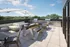 Chic rooftop terrace featuring modern lounge seating, elegant dining set, and stainless steel grills under stylish umbrellas, perfect for entertaining with scenic views.