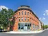 Charming historic brick building with large windows and elegant architecture under a clear blue sky.