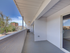 Spacious apartment balcony with a modern railing, offering scenic urban views and abundant natural light.