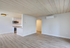 Bright and modern open-concept living area with sleek kitchen, featuring elegant wood flooring and contemporary light fixtures.
