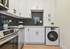 Sleek modern kitchen with stylish hexagonal backsplash, stainless steel appliances, and integrated washer for convenience.