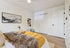 Inviting bedroom with a cozy fur throw, stylish artwork, and bright yellow accents, complemented by sleek white sliding closet doors.