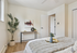 Bright and inviting bedroom featuring cozy decor, a modern plant, and stylish artwork.