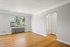 Bright, spacious room with polished hardwood floors, large window view, and elegant archway. Perfect for a cozy living area or home office.