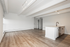 Modern open-plan apartment with sleek wood flooring, abundant natural light, and a stylish kitchen island with a contemporary faucet.