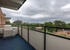Inviting apartment balcony with stunning cityscape and lush greenery views, perfect for relaxation and enjoying the outdoors.