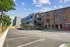 Charming apartment complex with modern and rustic architecture, featuring ample parking and electric vehicle charging stations under a clear blue sky.