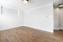 Bright and airy apartment with modern wood flooring, sleek white walls, and contemporary light fixtures, perfect for a stylish living space.