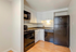 Modern kitchen with sleek black appliances, elegant cabinetry, and warm hardwood flooring, perfect for culinary adventures.