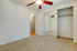 Bright and inviting bedroom with plush carpeting, mirrored closet doors, and elegant ceiling fan.
