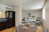 Chic open-concept living and dining area with a cozy corner sofa, modern decor, and a stylish dining table set for four.