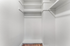 Spacious walk-in closet with clean white shelving and modern finishes, perfect for organizing and maximizing storage.