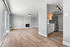 Chic open-concept living area with modern fireplace, sleek kitchen, and elegant wood flooring.