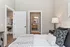 Inviting bedroom view leading to a modern bathroom, complemented by elegant decor and warm lighting.