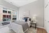 Bright and cozy bedroom with chic decor, large window offering city views, and elegant furniture perfect for relaxation.