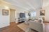 Bright and inviting living room with modern furniture, large window, sleek TV setup, and charming decor accents.
