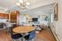 Modern and inviting open-concept living space featuring a cozy sitting area, stylish dining set, and sleek kitchen with wooden cabinets.