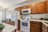 Cozy kitchen with warm wood cabinets, modern appliances, and chic decor; perfect for culinary adventures and dining with a view.