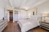 Elegant bedroom with modern decor featuring a cozy bed, stylish lamps on matching nightstands, and spacious closet space.