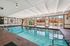 Luxurious indoor swimming pool with elegant tiled flooring and abundant natural light through large windows, perfect for relaxation and leisure in a sophisticated setting.