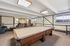 Inviting recreation room with a classic billiard table, cozy seating area, and vintage decor for leisurely entertainment.