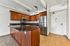 Modern kitchen with sleek granite countertops, stainless steel appliances, and rich wooden cabinetry, ideal for culinary enthusiasts.
