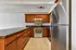 Modern kitchen with sleek stainless steel appliances, elegant wooden cabinetry, and a spacious granite countertop.
