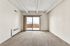 Bright and airy living room with plush carpet and sliding glass doors leading to a balcony with city views.