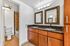 Elegant bathroom featuring dual sinks with marble countertops, framed mirrors, and warm wood cabinetry.