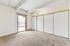Bright and spacious bedroom with large closet and a stunning city view, featuring plush carpet and modern design.