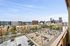 Stunning urban cityscape view from a high-rise balcony, showcasing a vibrant downtown skyline and bustling streets below.