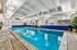 Inviting indoor swimming pool area with modern lighting and vibrant decor, perfect for relaxation.