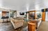 Elegant living room with vintage-patterned couches, a cozy fireplace, and an open kitchen bar area. Bright, inviting space with stylish d&eacute;cor and natural light.