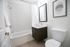 Old Town Chicago, IL, Apartments Near Wells Street - 1537 N Orleans - A Modern Bathroom With A Bathtub Shower Combo, A Dark Wood Vanity, A Toilet, And Minimalist Wall Art.