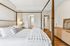 Elegant bedroom with a luxurious four-poster bed, stylish wooden flooring, and soft ambient lighting, offering a cozy and sophisticated retreat.