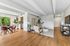 Modern open-concept apartment with elegant dining area, cozy living space, and natural light from large windows.
