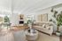 Speer, CO, Apartments Near Denver Country Club - El Greco Apartments - Bright Living Room With Beige Sofa, Armchair, Round Coffee Table, White Brick Fireplace, and Large Windows Beside a Nook.