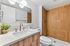 Contemporary bathroom featuring elegant fixtures, a chic wood-accented shower, and a stylish vanity with modern lighting.