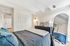 Elegant bedroom with modern decor, featuring a plush bed with cozy bedding, a sleek dresser, and a stylish arched mirror.
