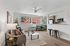 Bright and modern living room with large windows, cozy sofa, and stylish open kitchen. Ideal for relaxation and entertaining.