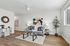 Modern living room with stylish decor, featuring a cozy gray sofa, abstract artwork, and natural light through a large window.
