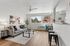Bright and airy living room with modern decor, featuring a cozy gray sofa, stylish artwork, and large windows letting in natural light.