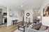 Bright, open-concept living room with modern decor, cozy seating, and sleek kitchen view; perfect for stylish living.