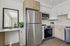 Modern kitchen with stainless steel appliances, sleek cabinetry, and a chic countertop with decorative plants.